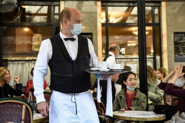 A waiter works at a cafe in Paris. 