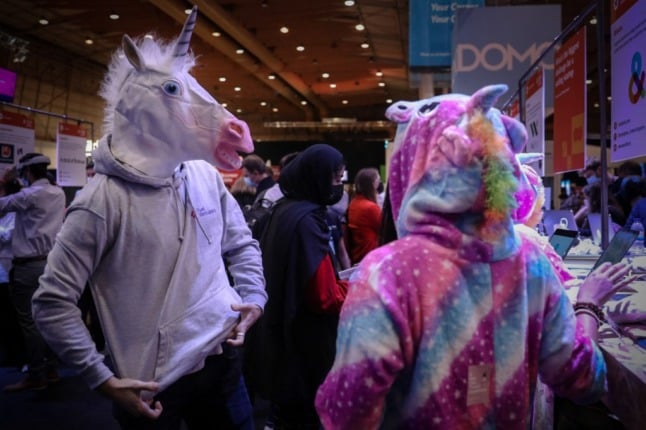 People dressed as unicorns attend a tech summit. 