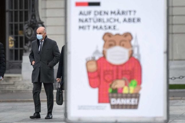 Swiss Health Minister Alain Berset walks past a poster reminding people to wear masks. Switzerland will decide on further Covid measures on Wednesday. Photo: Fabrice COFFRINI / AFP