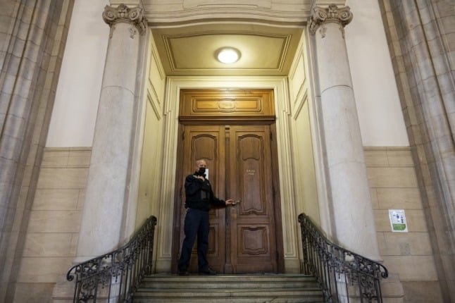 A judicial officer stands in front of a courtroom in Berlin.