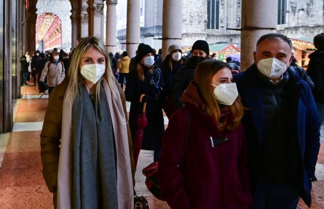 People walk in central Milan wearing FFP2 face masks.