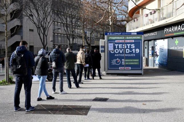 People queue outside a pharmacy to receive Covid-19 antigenic tests