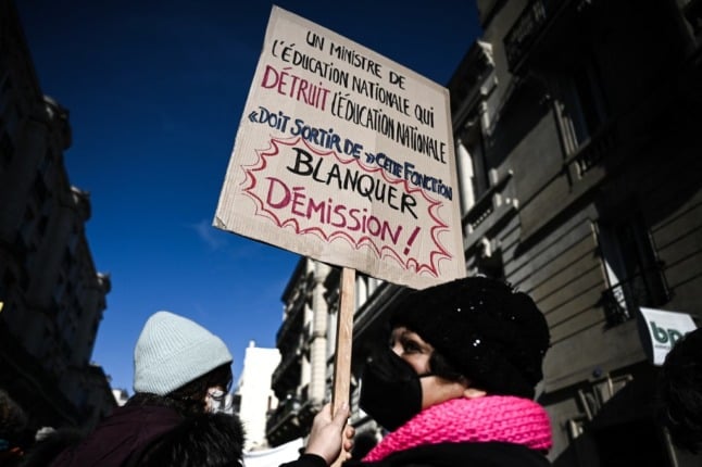 A French  protestor holds a sign calling for the Education Minister, Jean-Michel Blanquer, to resign.