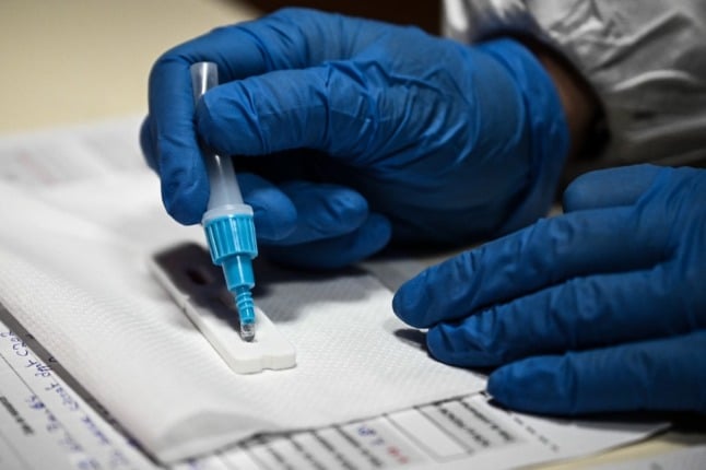 A French health worker performs an antigen test. 