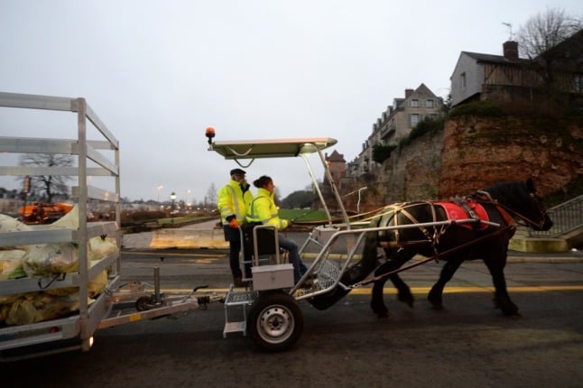 A horse draws a cart containing recyclable waste in the French town of Le Mans.