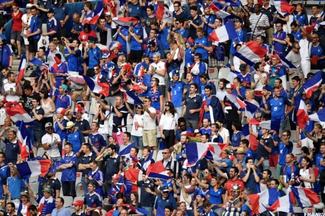 France football fans, many in bleu, blanc, rouge colours, waving flags at Stade de France
