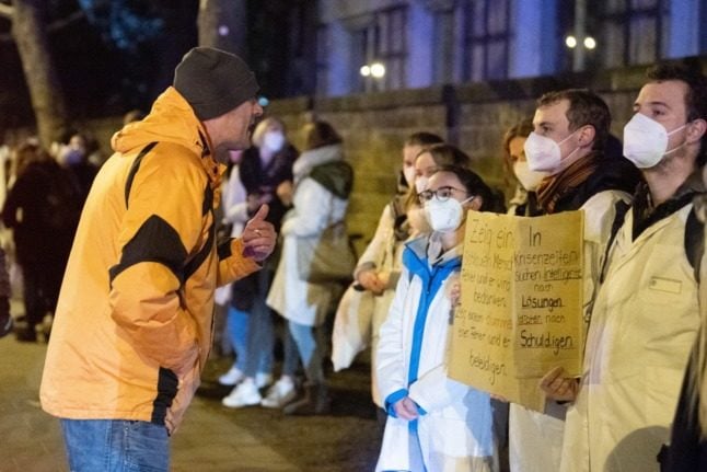 An anti-Covid measures protester confronts students in Dresden on Thursday.