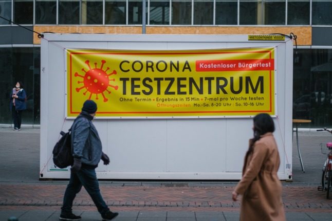 People walk past a Covid test centre in Hanover, Lower Saxony. 