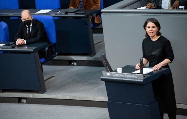 German Foreign Minister Annalena Baerbock speaks in the Bundestag, as Chancellor Olaf Scholz sits to her right.