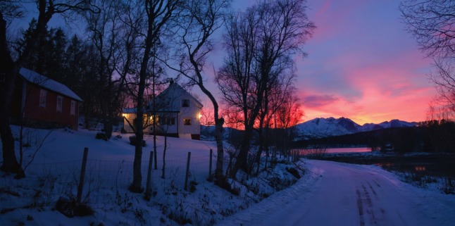A snow covered house at sunrise. 