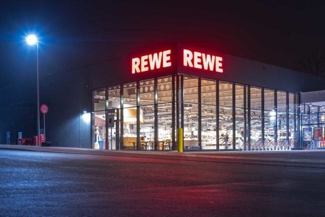 An outlet of German supermarket chain Rewe seen at night