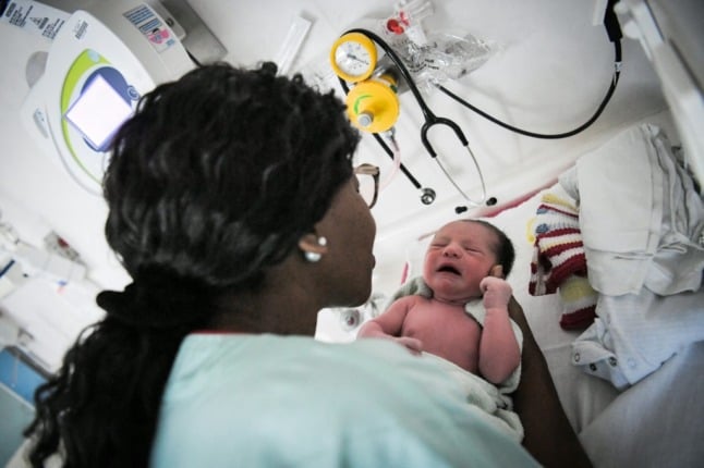 A nurse takes care of a newborn baby in France