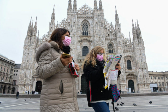 Tourists consult a map outside Milan's Duomo. Italy recently eased its Covid restrictions for boosted visitors. 