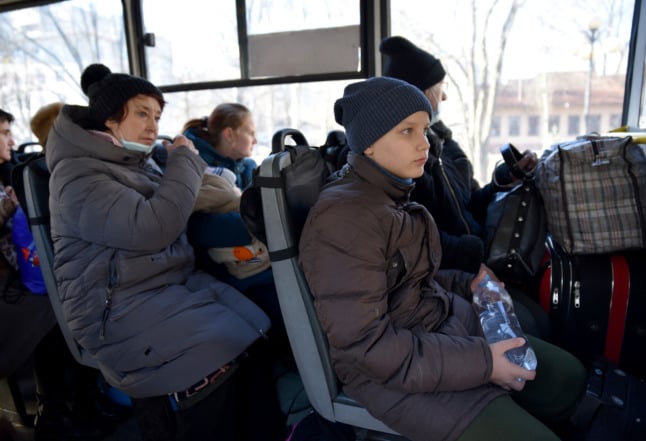 People sit in a bus for their evacuation in Donetsk on February 19, 2022. 
