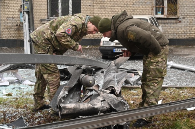 Ukrainian security personnel inspect the remains of a shell dropped in Kyiv on Thursday.