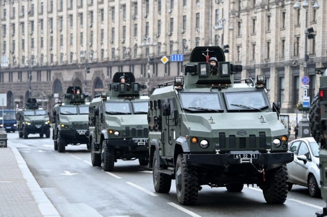 Ukrainian military vehicles drive through Kyiv.