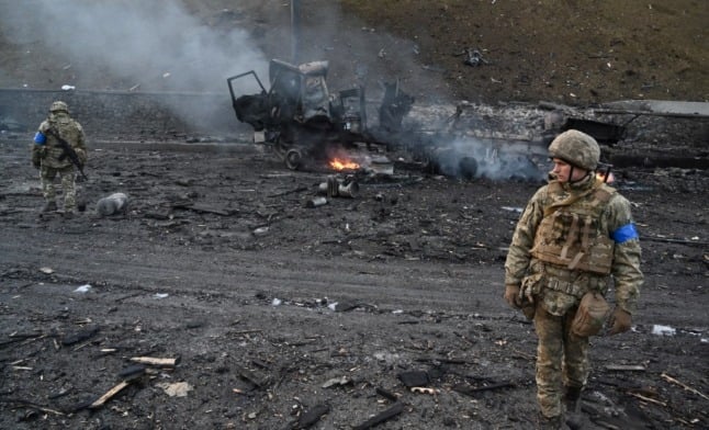 Ukrainian service members look for unexploded shells