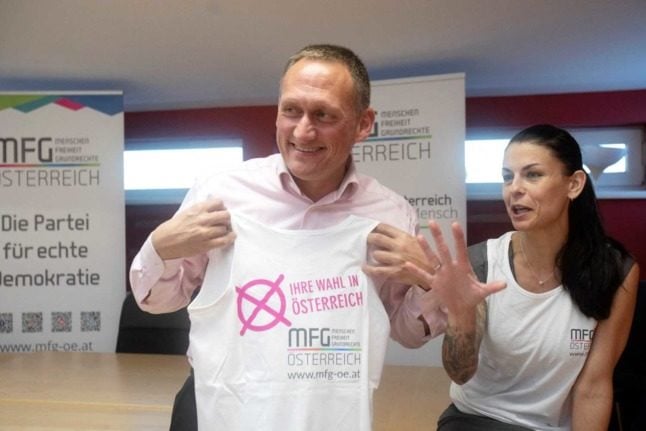 Gerhard Poettler, party founder of the MFG Party (short for People, Freedom, Fundamental Rights), and Dagmar Haeusler, member of the Upper Austrian state parliament and co-founder, pose with a t-shirt during an interview with AFP in Eugendorf, Austria, on January 24, 2022. Photo: ALEX HALADA / AFP