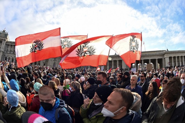 Demonstrators wave Austrian flags during a rally held by Austria's far-right Freedom Party FPOe