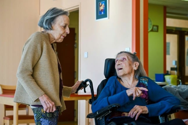 Hermine Saubion, 110, talks with another French care home resident.