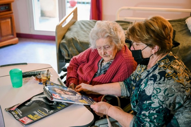 Aline Blain, 110, reads a magazine with her daughter Monique, in southern France.