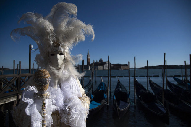 A masked figure poses in St Mark Square during Venice's Carnival on February 12, 2022.
