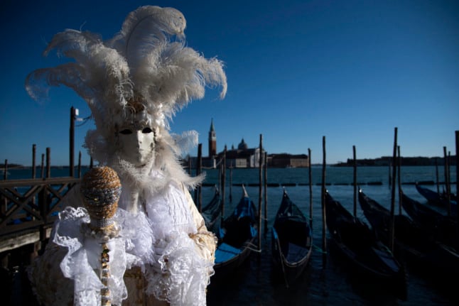 A masked figure poses in St Mark Square during Venice's Carnival on February 12, 2022. 