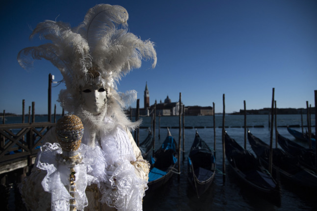 A masked figure poses in St Mark Square during Venice's Carnival on February 12, 2022. 