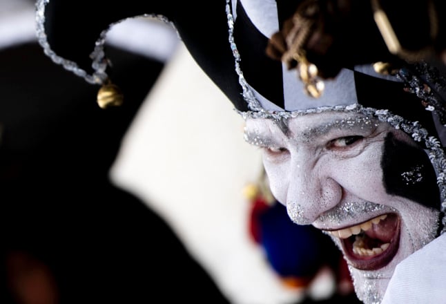 A masked reveller wearing a traditional carnival costume poses on St Mark Square during Venice's Carnival on February 13, 2022. 