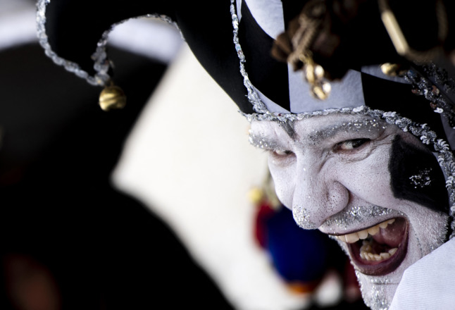 A masked reveller wearing a traditional carnival costume poses on St Mark Square during Venice's Carnival on February 13, 2022. 