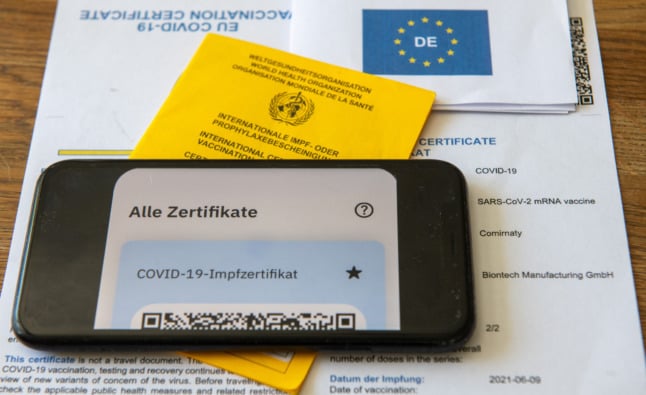 A vaccination booklet, EU vaccination certificate and smartphone 