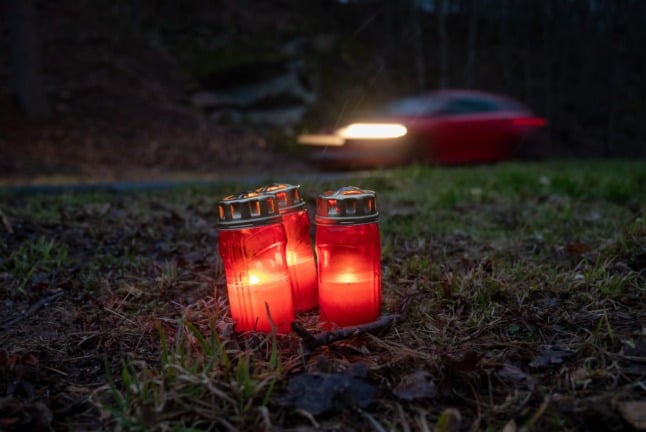 Candles stand near the road where two police offers were shot to death in western Germany.
