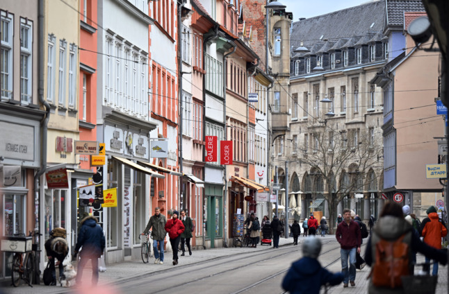 People walk on a shopping street in Erfurt. Some Covid measures like masks will remain in place.