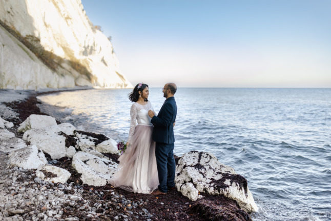 Married couple on a beach in Denmark.