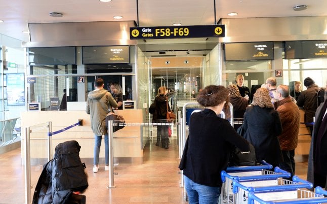 File photo of border police checking passports at Arlanda Airport.