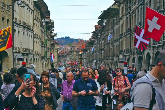 People walk through the streets of the Swiss capital of Bern