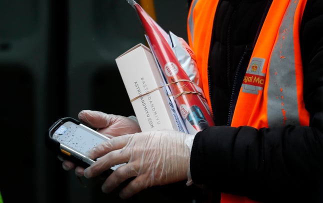 a royal mail employee carrying parcels