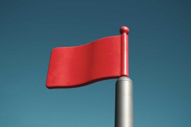 A red flag against a blue sky