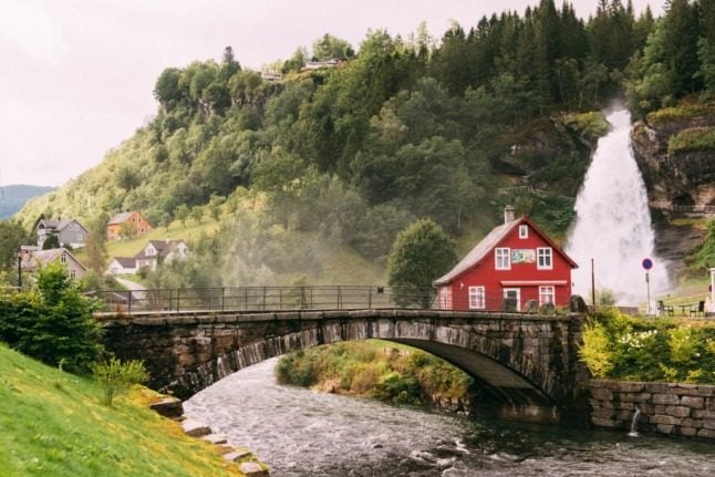 A house just by a bridge and waterfall in Norway.