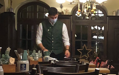 A waiter wearing a mask. 