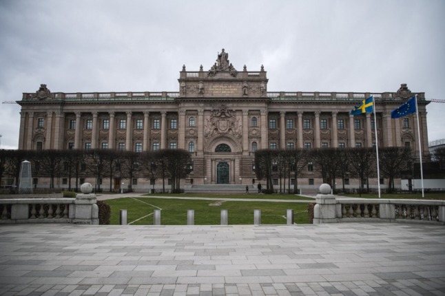 The Swedish and EU flags fly in front of the Swedish Parliament in Stockholm. 