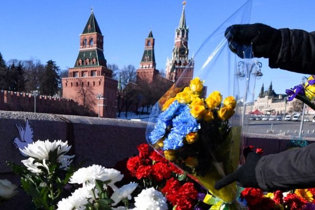 People lay flowers at the site where late opposition leader Boris Nemtsov was fatally shot on a bridge near the Kremlin in central Moscow on February 27, 2022, on the seventh anniversary of his assassination. Photo: Alexander NEMENOV / AFP