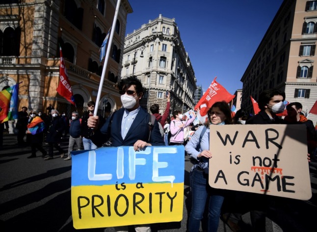 Demonstrators in Rome hold signs protesting Russia's invasion of Ukraine