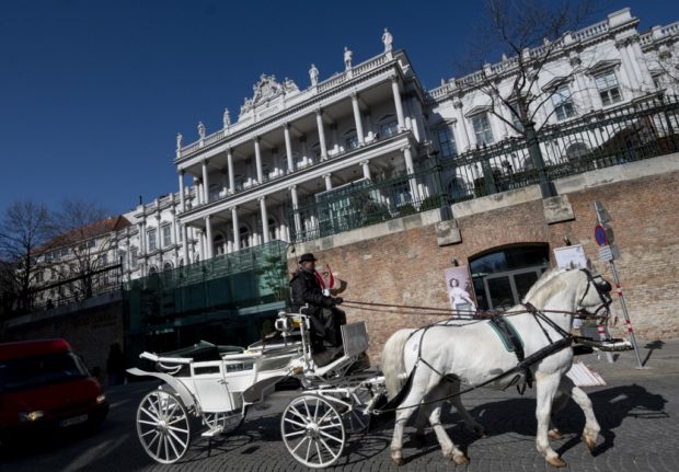 Horses with carriages are passing by the Coburg Palais