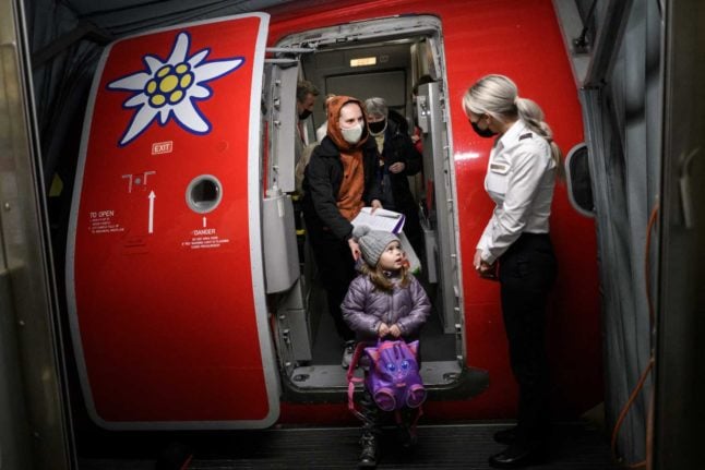 Ukrainian refugees exit a plane chartered by a Swiss millionaire at Zurich Airport, on March 22, 2022. Photo: FABRICE COFFRINI / AFP