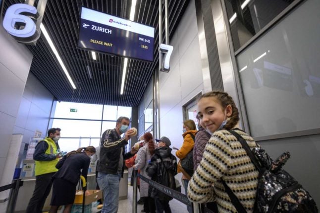 A young Ukrainian refugee boards a plane headed to Zurich from Krakow. Photo: FABRICE COFFRINI / AFP