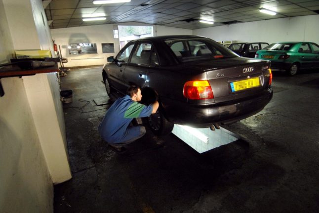 A mechanic performs a contrôle technique on a car in France. Garages warn of a backlog at the beginning of summer.