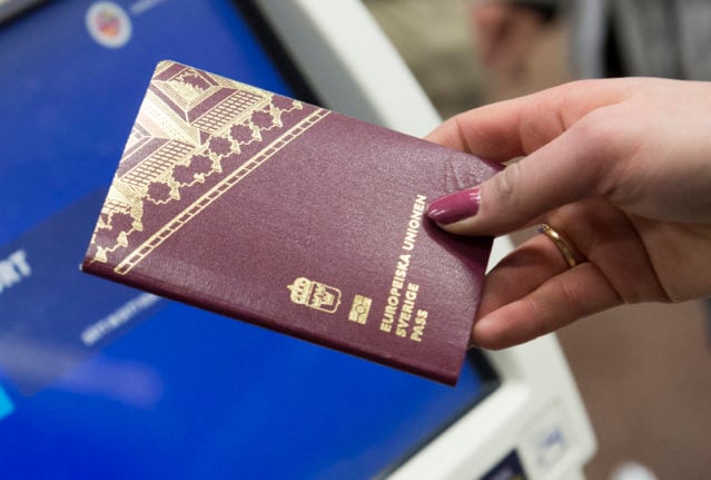 A Swedish passport is held in front of an automatic check-in machine at Stockholm's Arlanda Airport.