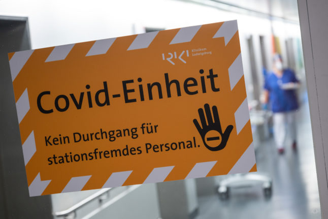 A sign on a glass door at the RKH Klinikum Ludwigsburg shows the Covid unit.