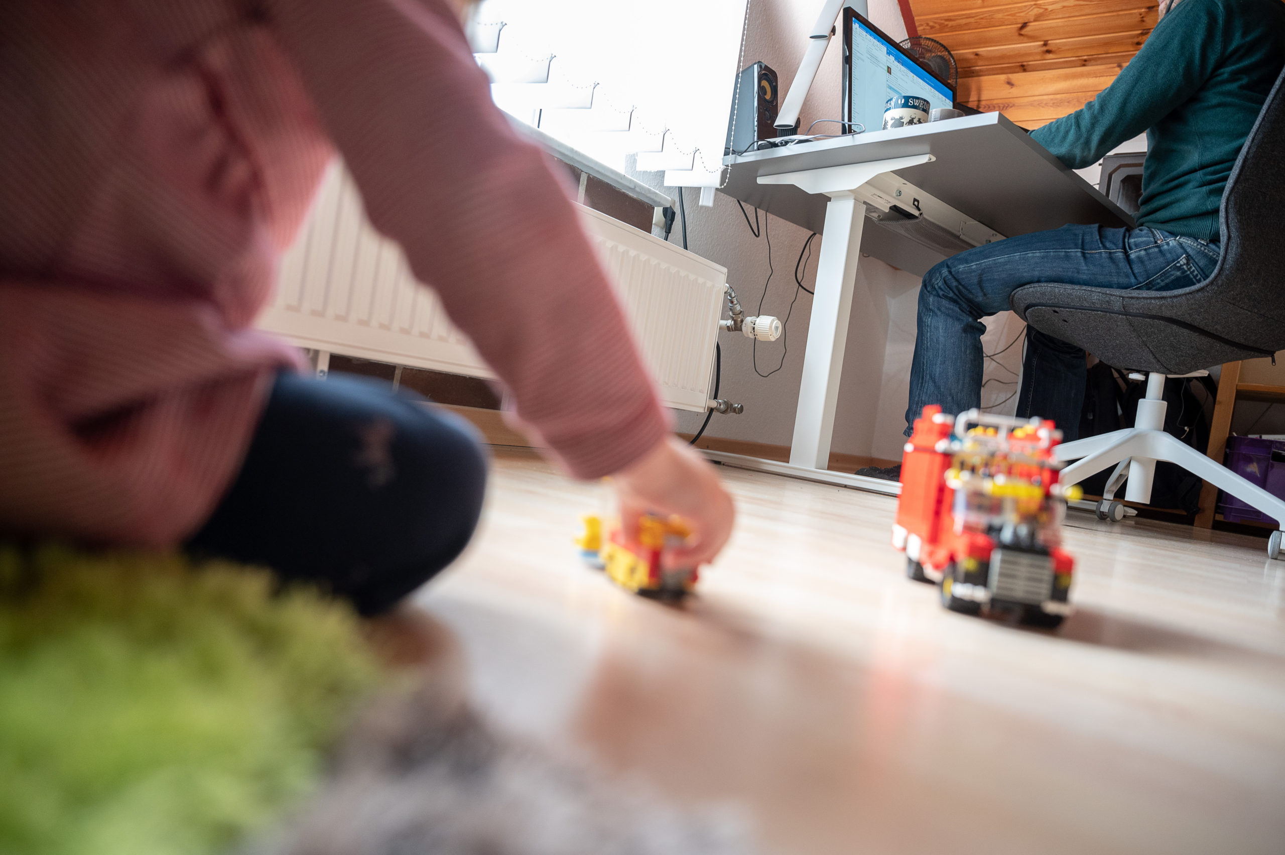 A man works from home with his child. 